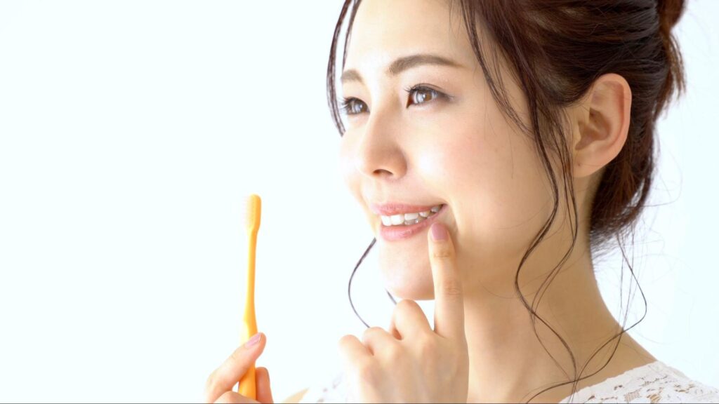 歯ブラシを持って笑顔の女性
