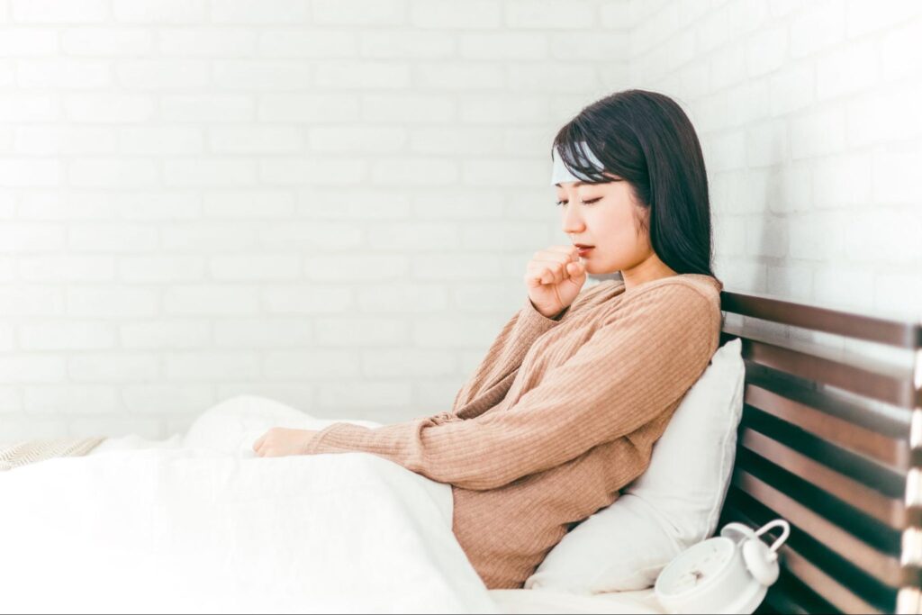 発熱しベッドに入っている女性