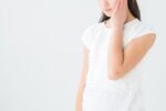 親知らずの痛みで頬を押さえる中学生
