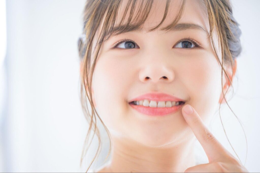 笑顔で歯を指差す女性