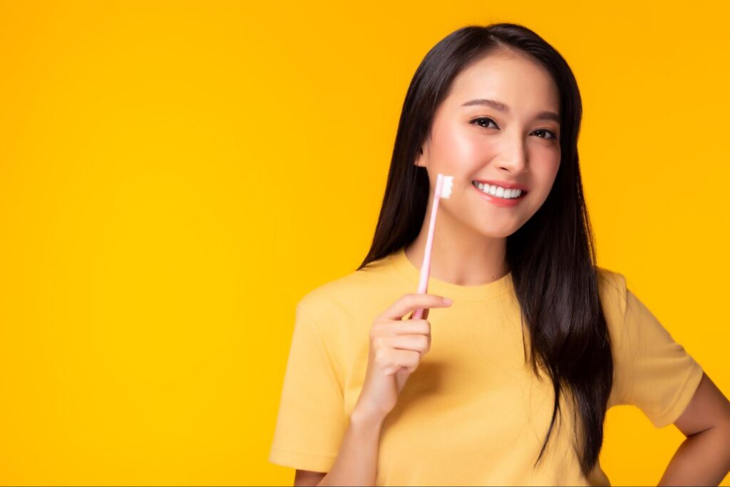 歯ブラシを持って笑顔の女性