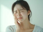 親知らずの腫れや痛みに顔をしかめる女性