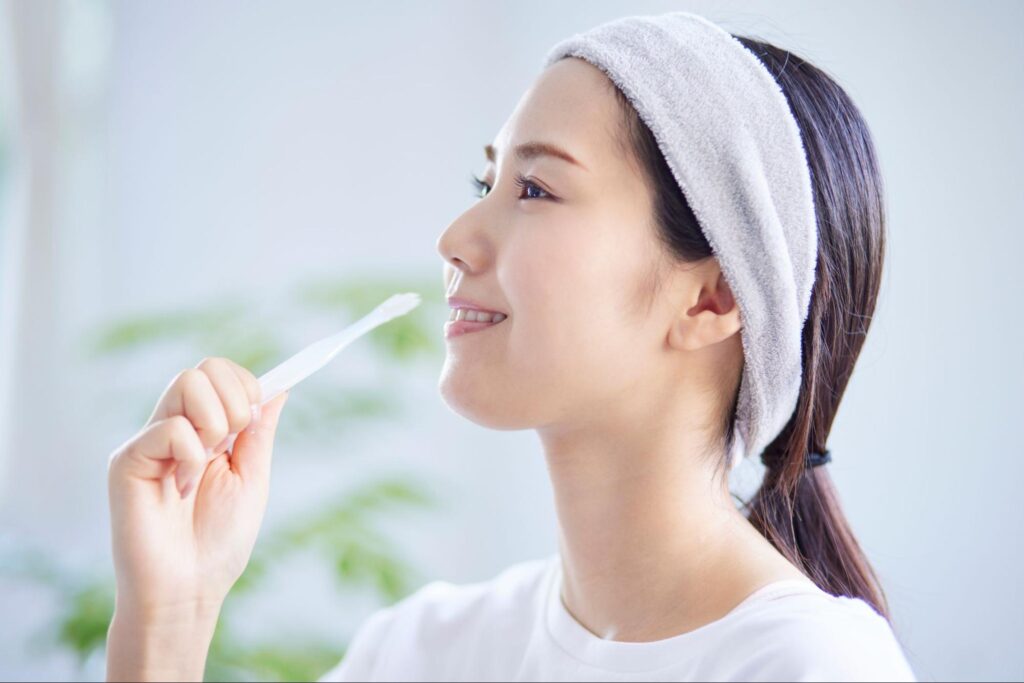 笑顔で歯を磨く女性