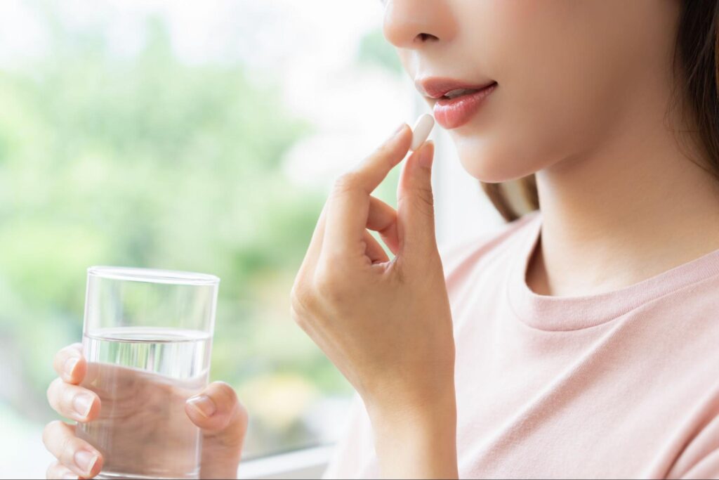 虫歯が痛み、痛み止めを飲む女性