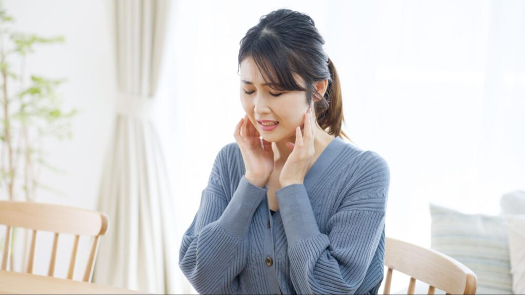 親知らずの腫れがあり耳の下あたりを押さえる女性