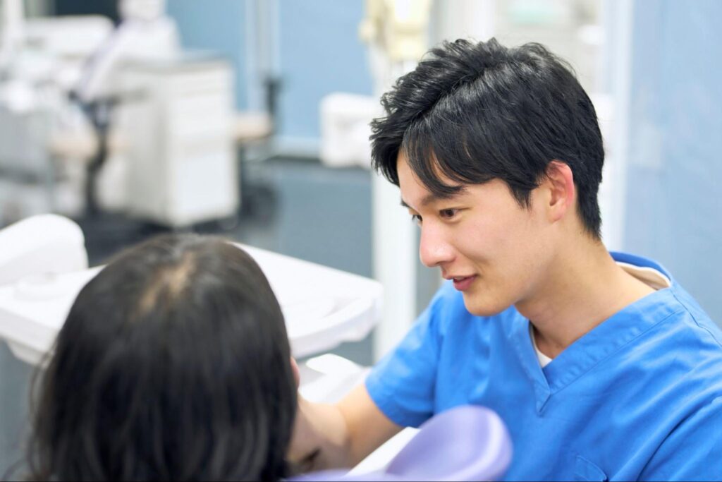 歯のチェックをする医師と患者の中学生
