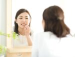 鏡で歯をチェックする女性