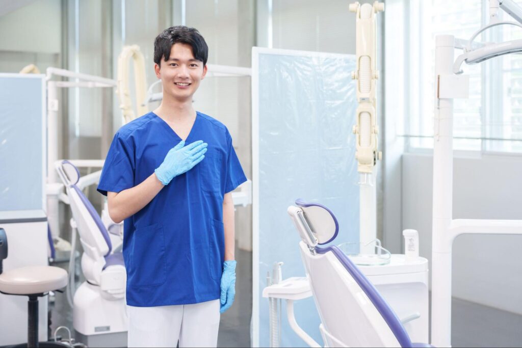 処置用の椅子の前に立つ男性歯科医師