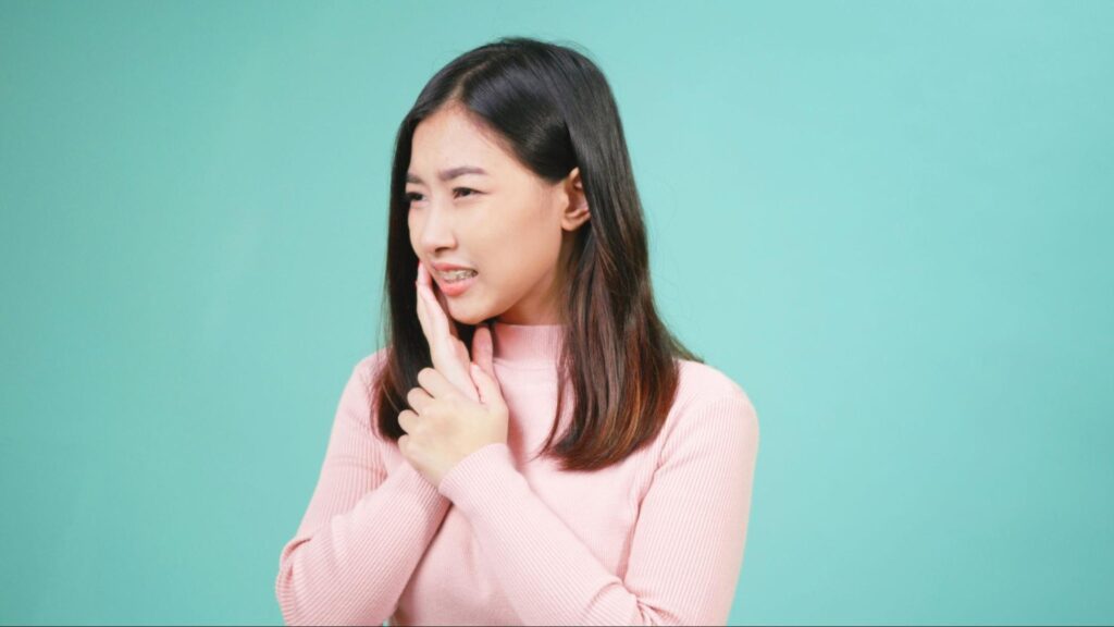 親知らずが痛み頬を押さえる女性
