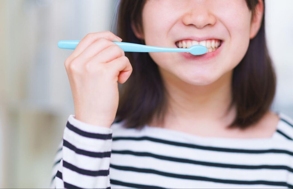 笑顔で歯磨きする女性