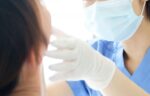 患者の口腔内をチェックする医師