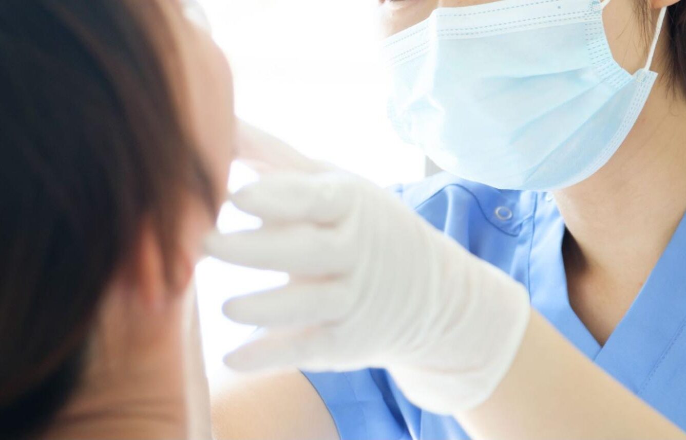 患者の口腔内をチェックする医師