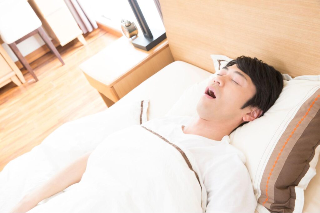 口を開けていびきをかいている男性