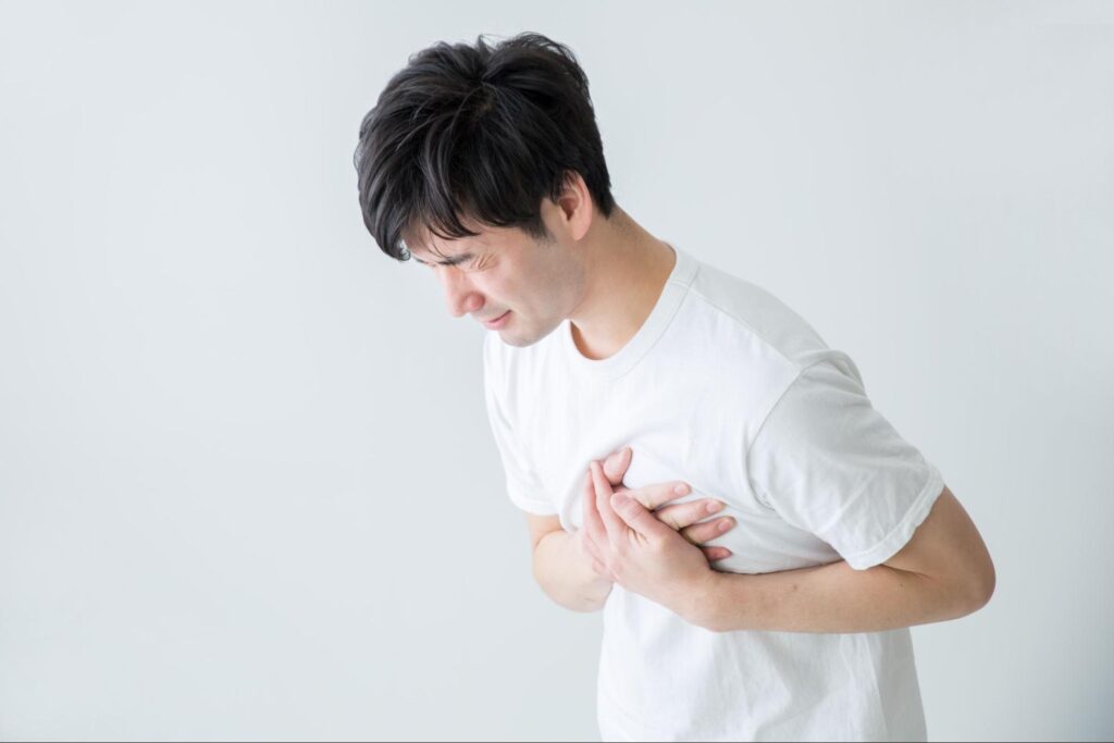 苦しげに心臓を押さえている男性