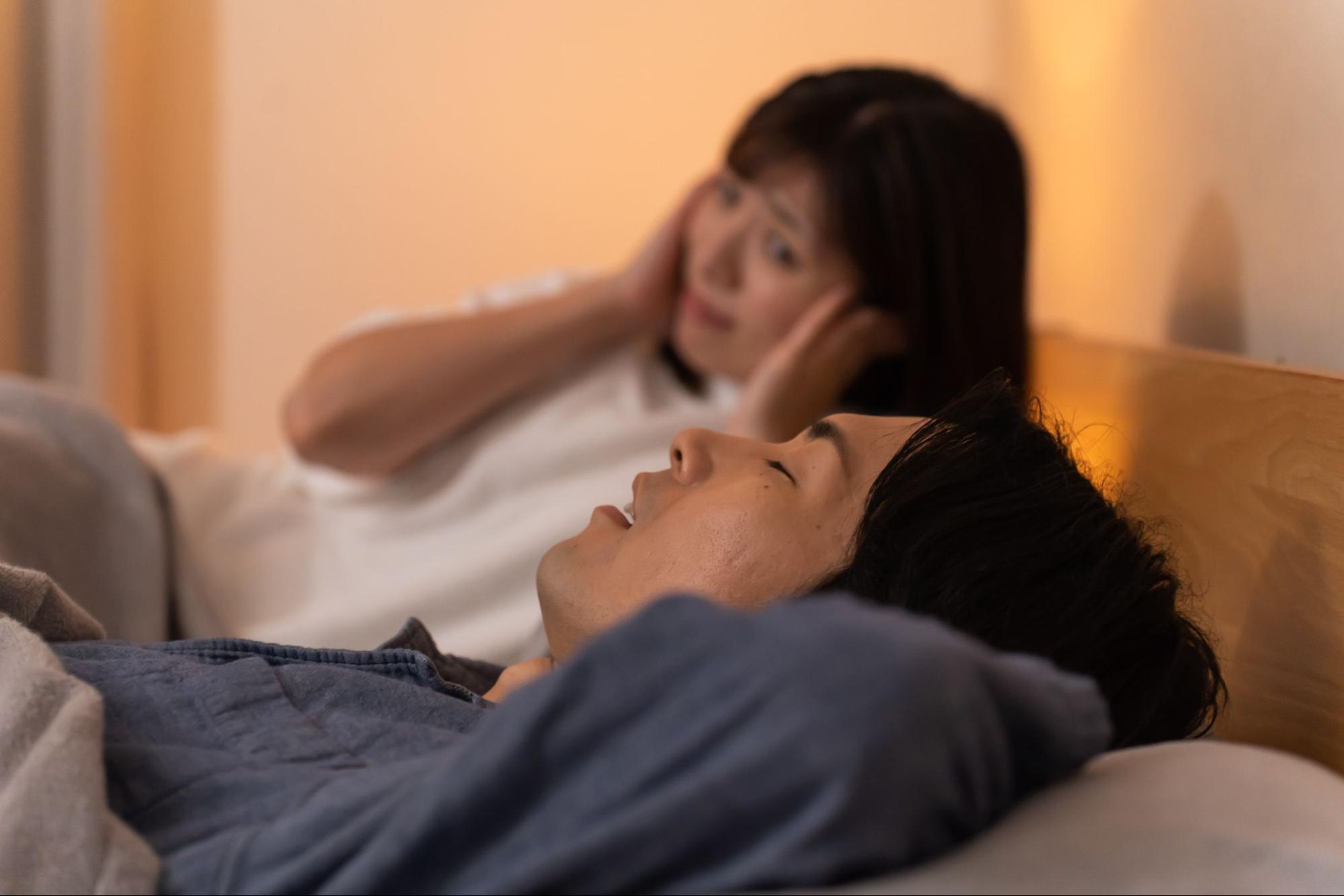 夫のいびきに耳を塞ぐ妻