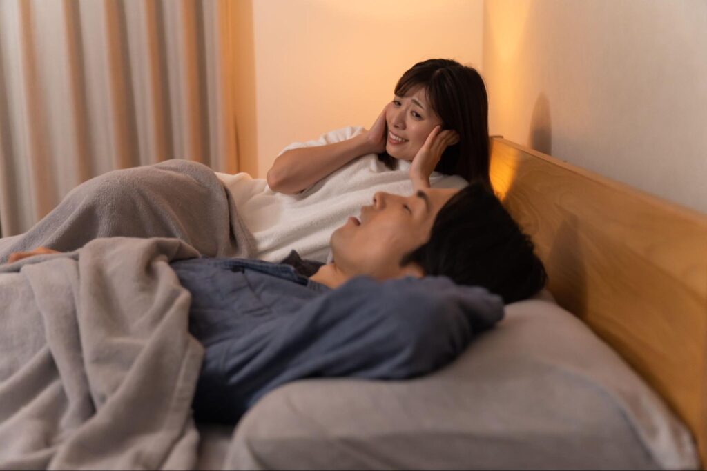 睡眠時無呼吸症候群の夫のいびきに耳を塞ぐ妻