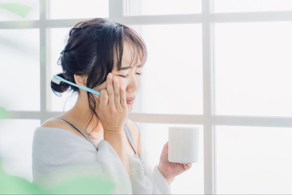 歯を押さえる女性